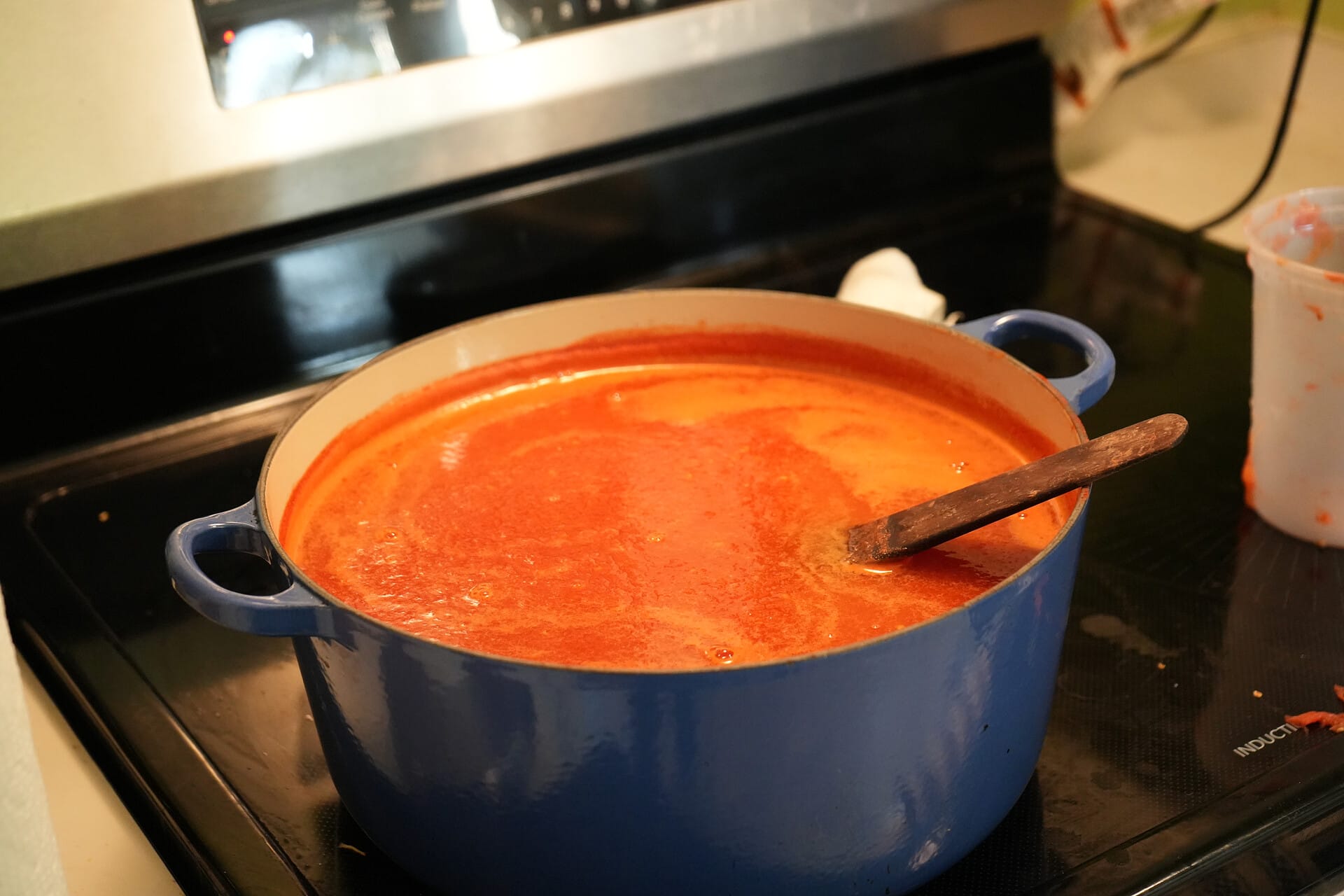 Pot filled with tomato sauce on a stove-top